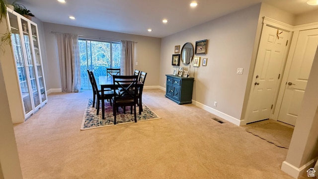dining space featuring light colored carpet, recessed lighting, visible vents, and baseboards