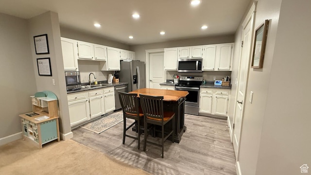 kitchen featuring stainless steel appliances, recessed lighting, butcher block countertops, and a sink