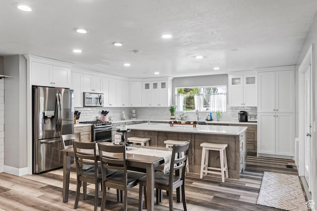 2490 W 12195 S, Riverton, UT 84065 - kitchen with appliances with stainless steel finishes, recessed lighting, a center island, light countertops, and decorative backsplash