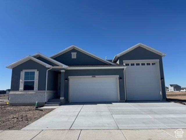 view of front of property with a garage, concrete driveway, and stucco siding
