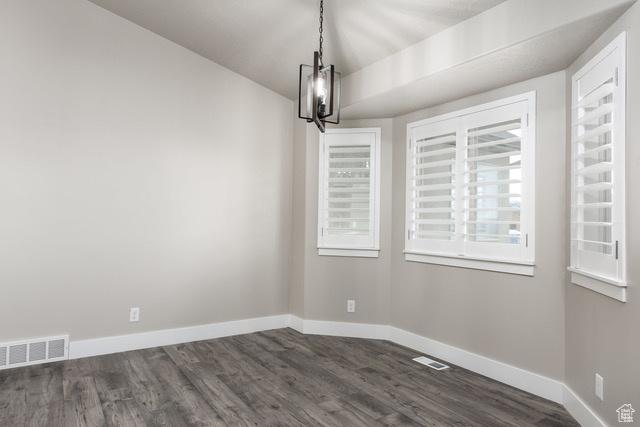 154 S Liberty St Unit 204, Grantsville, UT 84029 - unfurnished dining area with visible vents, baseboards, an inviting chandelier, and dark wood finished floors