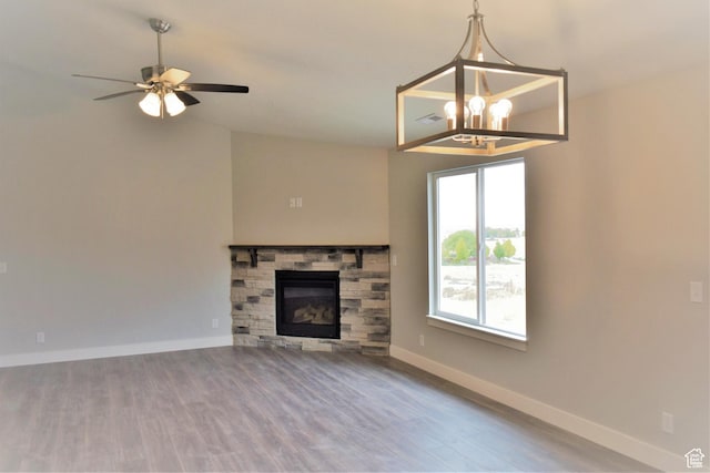 154 S Liberty St Unit 204, Grantsville, UT 84029 - unfurnished living room featuring baseboards, lofted ceiling, ceiling fan with notable chandelier, a fireplace, and wood finished floors