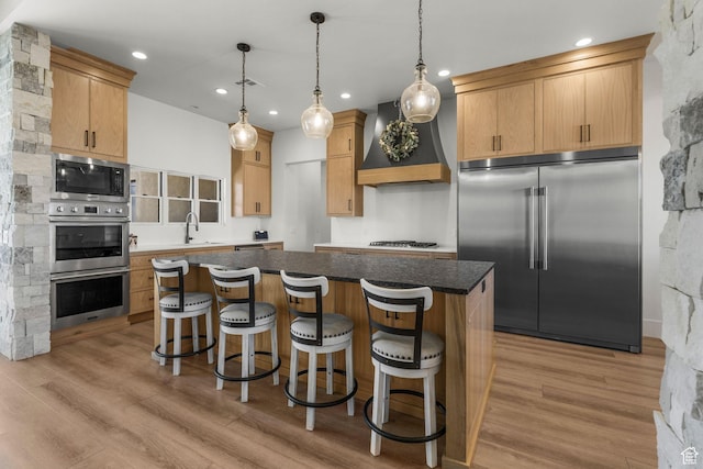 501 W 2300 S, Richfield, UT 84701 - kitchen featuring light wood-style flooring, custom range hood, a kitchen island, built in appliances, and a sink