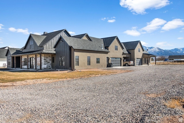 501 W 2300 S, Richfield, UT 84701 - view of front of house with a garage, roof with shingles, a mountain view, board and batten siding, and stucco siding