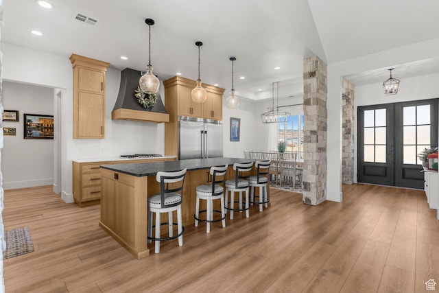 501 W 2300 S, Richfield, UT 84701 - kitchen featuring light wood finished floors, custom range hood, visible vents, light brown cabinetry, and stainless steel built in refrigerator
