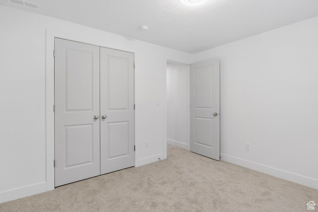 271 N 1160 N Unit 32, Tooele, UT 84074 - unfurnished bedroom featuring visible vents, baseboards, carpet, a textured ceiling, and a closet