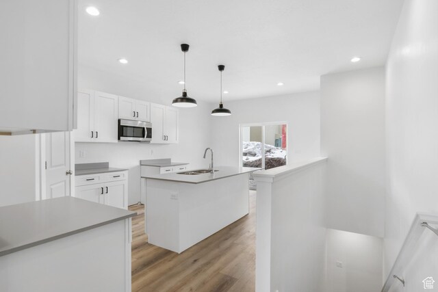 271 N 1160 N Unit 32, Tooele, UT 84074 - kitchen featuring recessed lighting, a sink, white cabinets, light wood finished floors, and stainless steel microwave