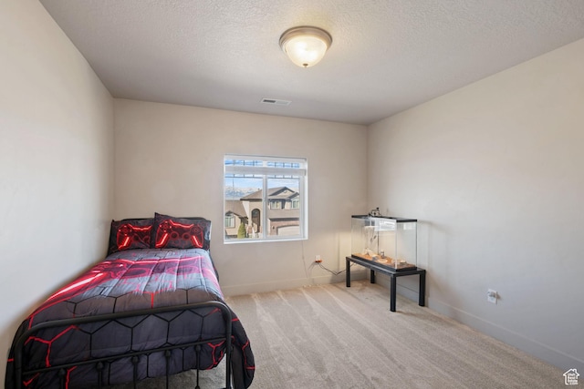 bedroom with visible vents, carpet flooring, a textured ceiling, and baseboards