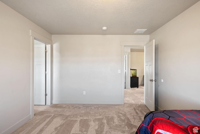 carpeted bedroom with visible vents, baseboards, and a textured ceiling