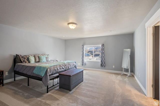 bedroom with baseboards, a textured ceiling, and light colored carpet
