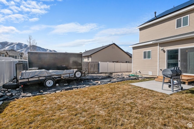 view of yard featuring a fenced backyard, a patio, and a mountain view