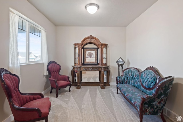 living area featuring visible vents, baseboards, and carpet flooring