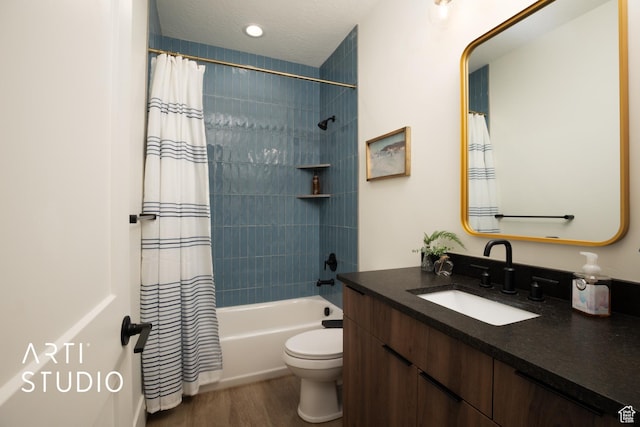 full bath featuring toilet, wood finished floors, shower / tub combo with curtain, a textured ceiling, and vanity