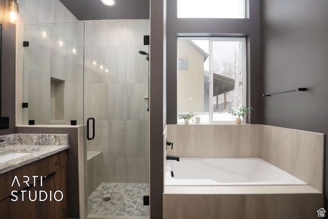 full bath with a bath, a shower stall, a wealth of natural light, and vanity