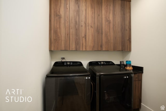 washroom featuring cabinet space and separate washer and dryer