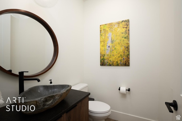 half bathroom with toilet and vanity