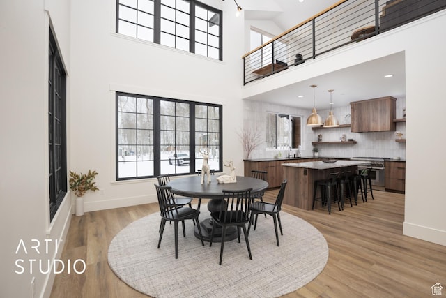 dining room featuring recessed lighting, baseboards, a healthy amount of sunlight, and light wood finished floors