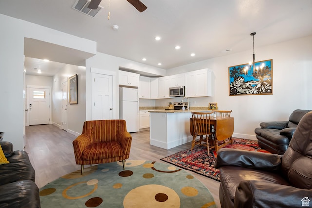 336 N 100 W, Morgan, UT 84050 - living room with recessed lighting, ceiling fan with notable chandelier, visible vents, baseboards, and light wood-style floors
