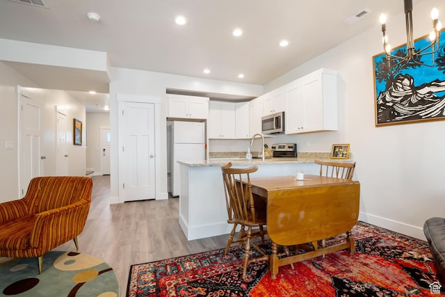 336 N 100 W, Morgan, UT 84050 - kitchen with visible vents, white cabinets, appliances with stainless steel finishes, light stone counters, and a peninsula