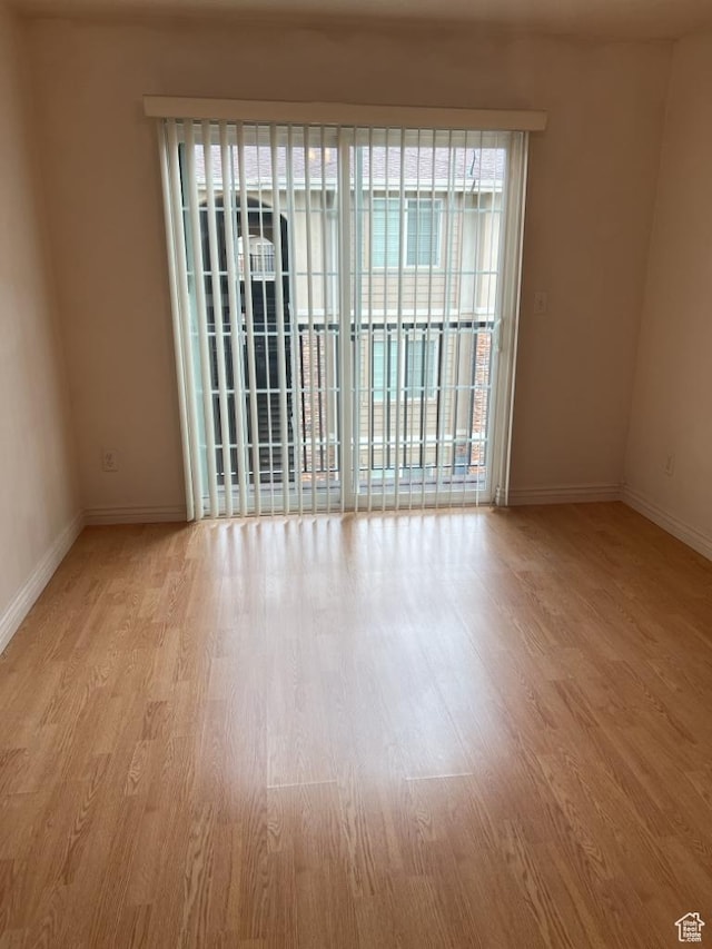 empty room featuring wood finished floors and baseboards