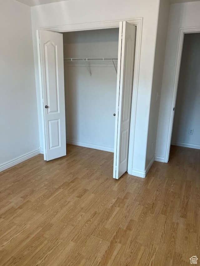 196 E Spencer Peak Way S Unit D9, Draper, UT 84020 - unfurnished bedroom featuring light wood-style floors, baseboards, and a closet