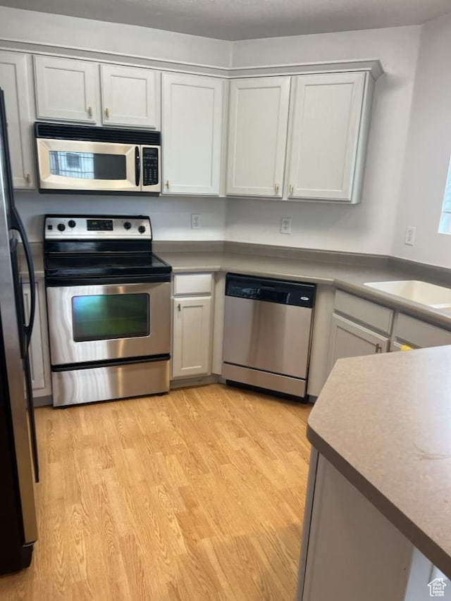 196 E Spencer Peak Way S Unit D9, Draper, UT 84020 - kitchen with stainless steel appliances, a sink, and light wood-style floors