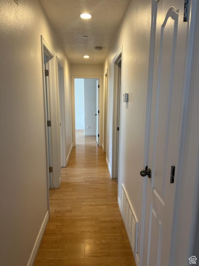 196 E Spencer Peak Way S Unit D9, Draper, UT 84020 - hallway with baseboards, visible vents, light wood-style flooring, a textured ceiling, and recessed lighting