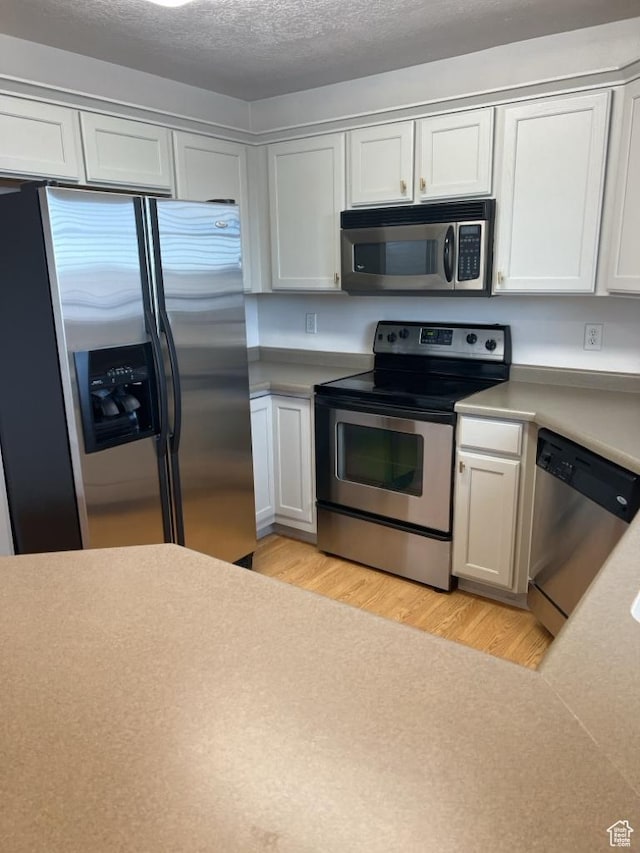196 E Spencer Peak Way S Unit D9, Draper, UT 84020 - kitchen featuring light wood-style flooring, stainless steel appliances, a textured ceiling, and light countertops