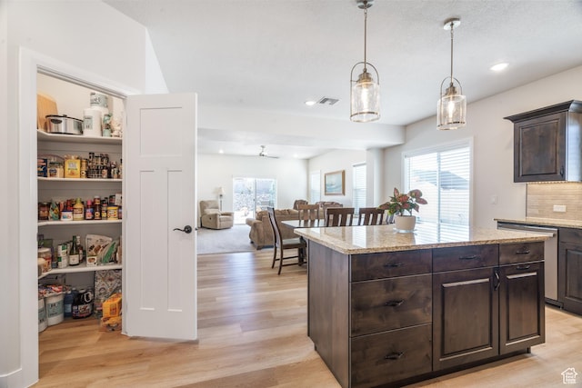 1044 E Southern Homestead Blvd, Enoch, UT 84721 - kitchen with light stone counters, tasteful backsplash, visible vents, light wood-style flooring, and dark brown cabinets