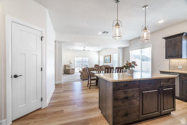 1044 E Southern Homestead Blvd, Enoch, UT 84721 - kitchen featuring dark brown cabinetry, visible vents, stainless steel dishwasher, light wood-type flooring, and tasteful backsplash