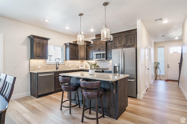 1044 E Southern Homestead Blvd, Enoch, UT 84721 - kitchen with stainless steel appliances, dark brown cabinets, light wood-type flooring, and a kitchen island
