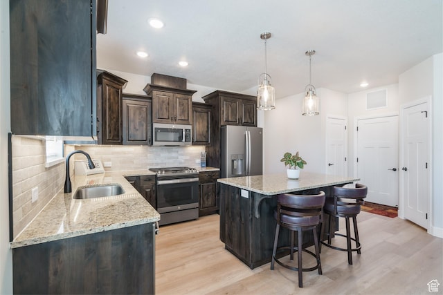 1044 E Southern Homestead Blvd, Enoch, UT 84721 - kitchen featuring dark brown cabinetry, appliances with stainless steel finishes, a sink, light wood-style floors, and backsplash