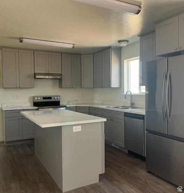1943 S State St, Roosevelt, UT 84066 - kitchen with dark wood-style flooring, under cabinet range hood, gray cabinetry, a sink, and appliances with stainless steel finishes