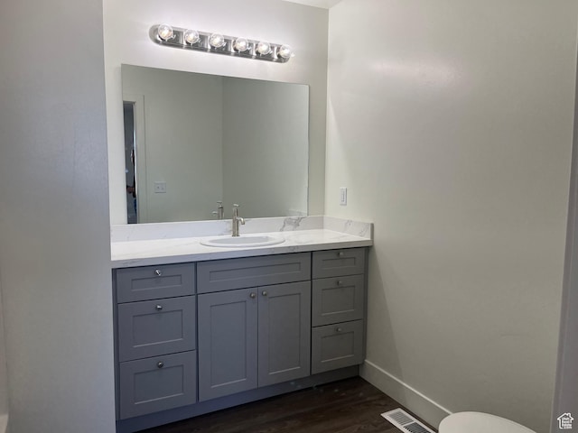 1943 S State St, Roosevelt, UT 84066 - bathroom with baseboards, visible vents, wood finished floors, and vanity