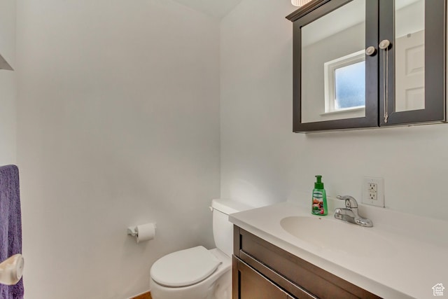 half bath featuring vanity and toilet