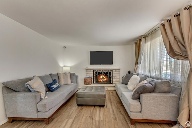 living room with a fireplace and light wood-style flooring
