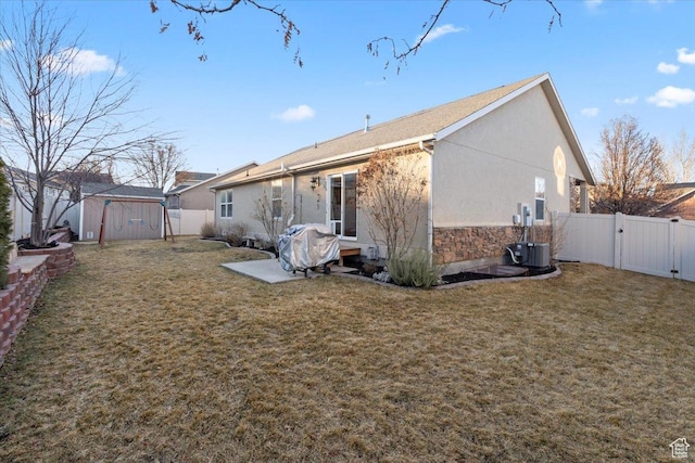 5009 W Greenstreak Dr, Riverton, UT 84096 - rear view of house featuring a lawn, an outdoor structure, a fenced backyard, and a gate