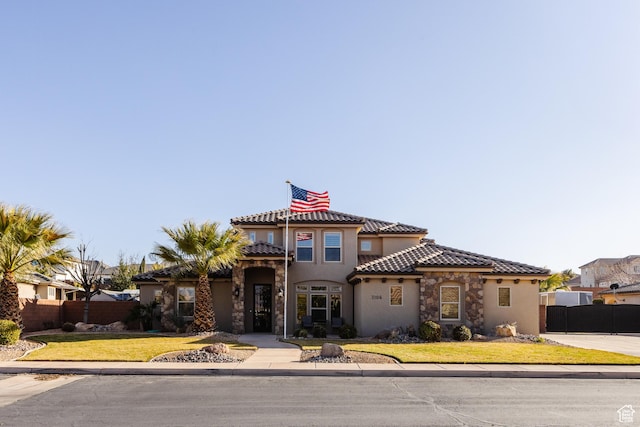 3106 E 2720 S, St George, UT 84790 - mediterranean / spanish house with stone siding, fence, a tiled roof, and stucco siding