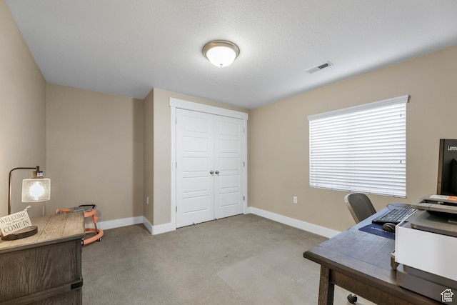 carpeted home office featuring visible vents and baseboards