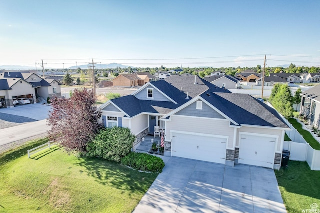 view of front facade with concrete driveway, a front yard, fence, and a residential view