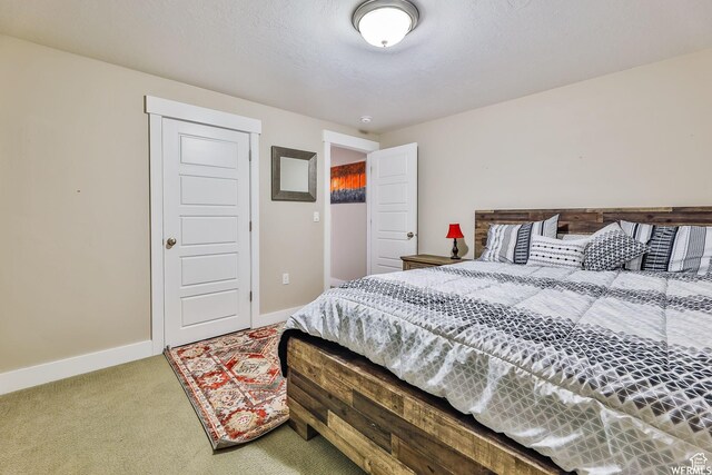 carpeted bedroom featuring baseboards and a textured ceiling