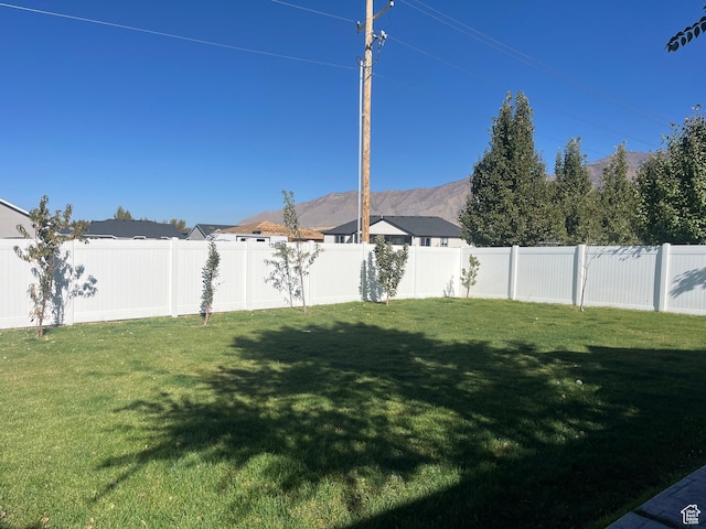 view of yard featuring a fenced backyard and a mountain view