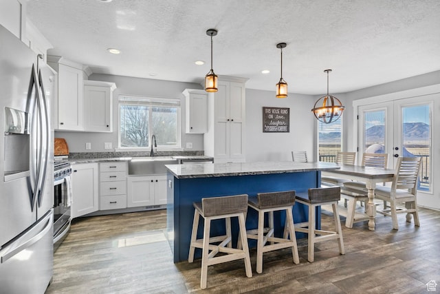 180 S Main St, Fayette, UT 84630 - kitchen with stainless steel appliances, wood finished floors, a kitchen island, a sink, and light stone countertops