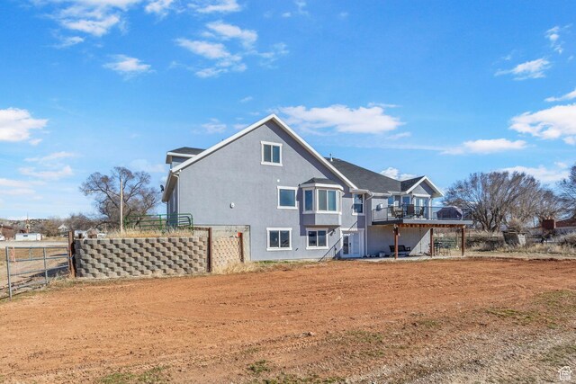 180 S Main St, Fayette, UT 84630 - rear view of property featuring a deck, stairway, fence, and stucco siding
