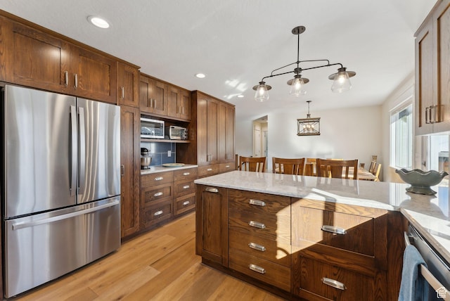 770 N 1000 E, Lehi, UT 84043 - kitchen with pendant lighting, appliances with stainless steel finishes, light wood-style floors, and light stone countertops
