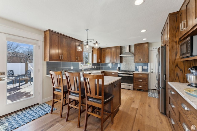 770 N 1000 E, Lehi, UT 84043 - kitchen with light wood-type flooring, wall chimney exhaust hood, backsplash, and stainless steel appliances
