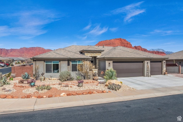 530 W Cougar Way, Ivins, UT 84738 - view of front of property with concrete driveway, stucco siding, fence, an attached garage, and a mountain view