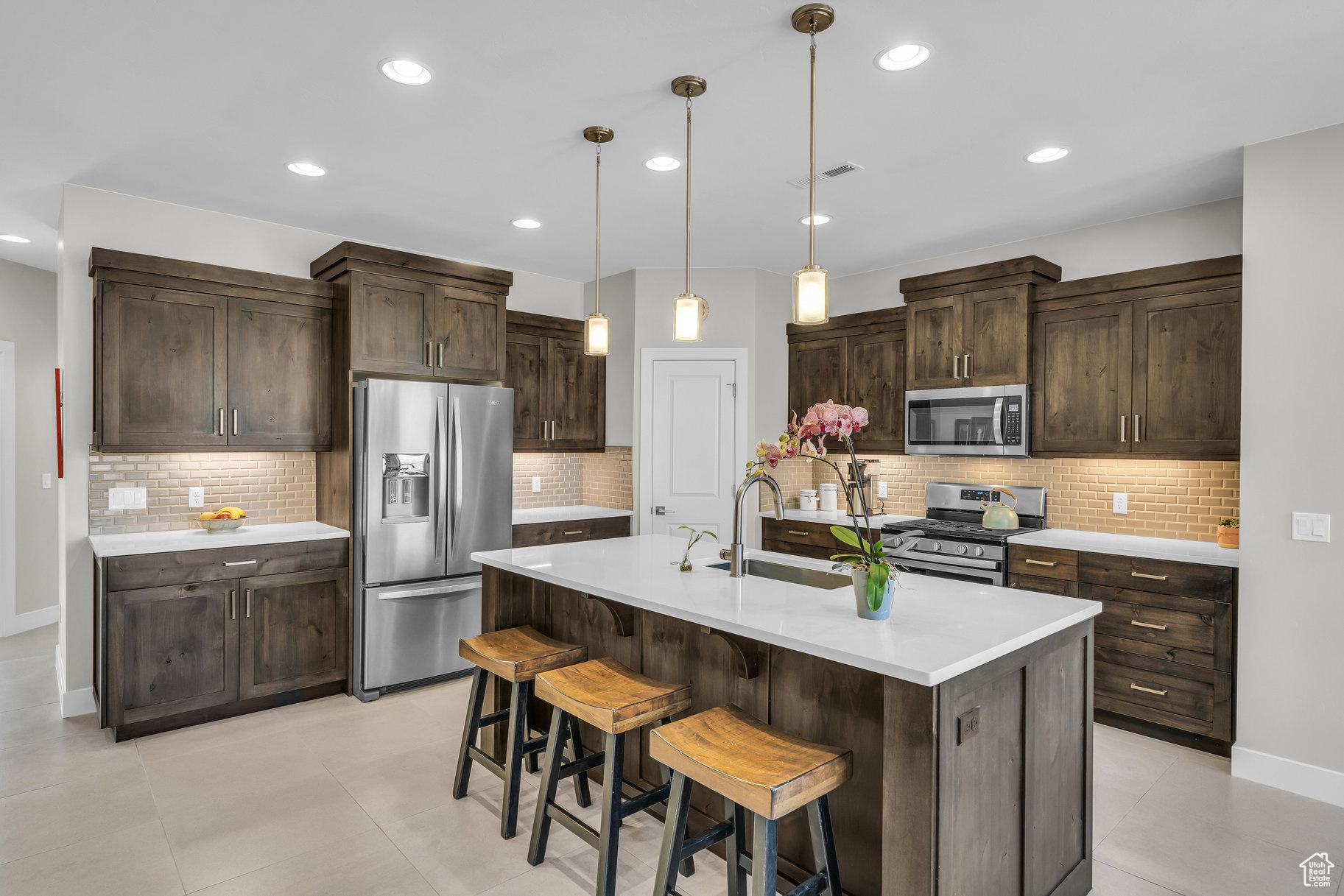 530 W Cougar Way, Ivins, UT 84738 - kitchen with dark brown cabinetry, light countertops, a sink, and appliances with stainless steel finishes