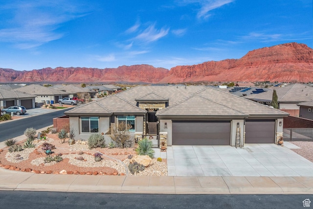 530 W Cougar Way, Ivins, UT 84738 - ranch-style house with stone siding, concrete driveway, stucco siding, a garage, and a mountain view