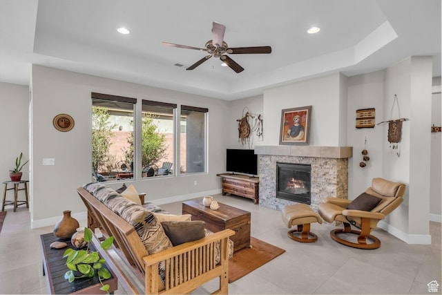 530 W Cougar Way, Ivins, UT 84738 - living room featuring baseboards, a glass covered fireplace, a ceiling fan, and a raised ceiling